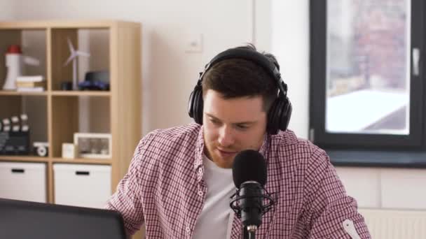 Hombre en auriculares con portátil habla al micrófono — Vídeos de Stock