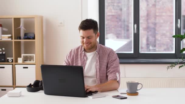 Joven feliz con el ordenador portátil en la oficina — Vídeos de Stock