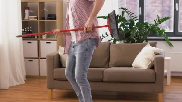 Homem com vassoura limpeza e se divertindo em casa — Vídeo de Stock