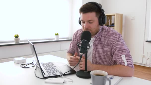 Mann mit Kopfhörer und Laptop spricht zum Mikrofon — Stockvideo