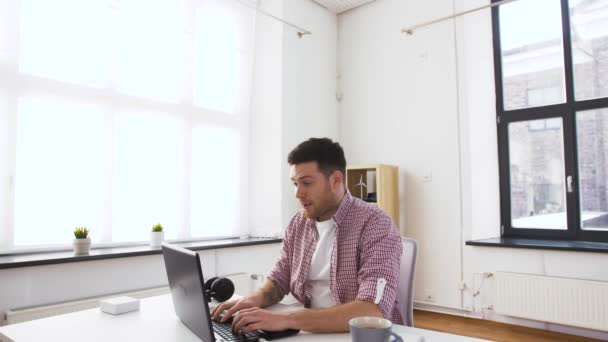 Heureux jeune homme avec ordinateur portable au bureau — Video