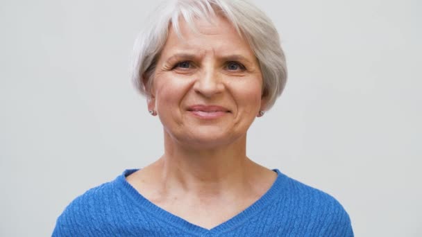 Portret van lachende Senior vrouw over grijs — Stockvideo