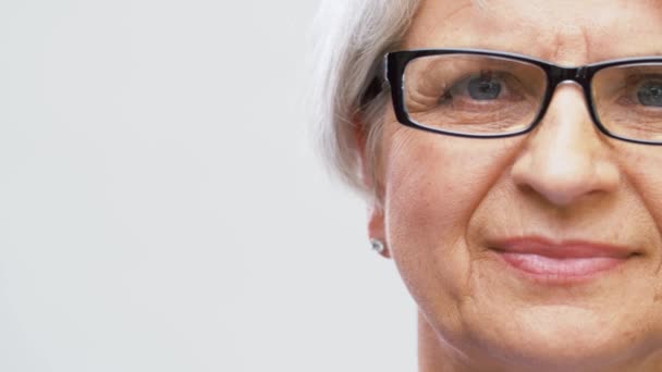 Портрет пожилой женщины, регулирующей очки — стоковое видео