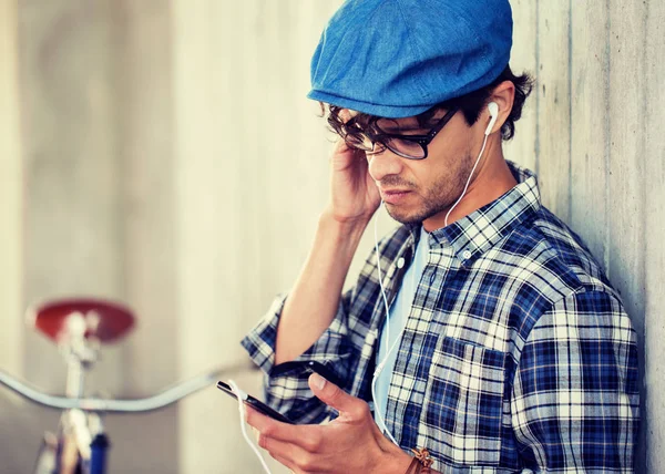 Hipster hombre con auriculares, smartphone y bicicleta —  Fotos de Stock