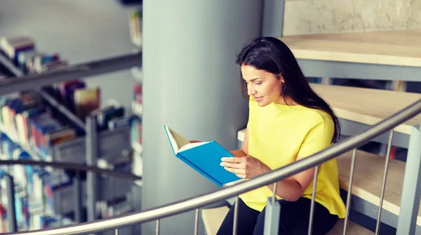 Estudiante de secundaria chica leyendo libro en la biblioteca — Foto de Stock