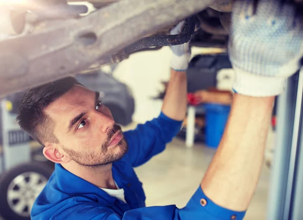 Механічний чоловік або коваль ремонтує автомобіль на майстерні — стокове фото