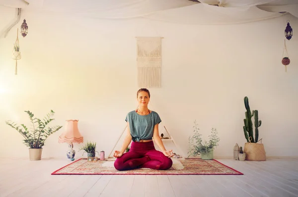 Vrouw mediteren in lotus poseren in yoga studio — Stockfoto