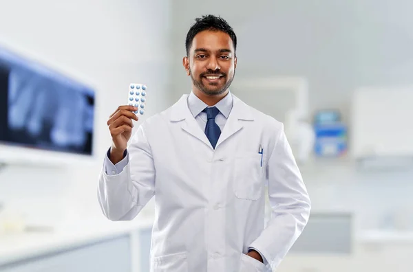 Indian male dentist with pills at dental clinic — Stock Photo, Image