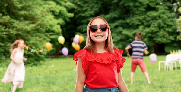 Girl in heart shaped sunglasses at birthday party — Stock Photo, Image