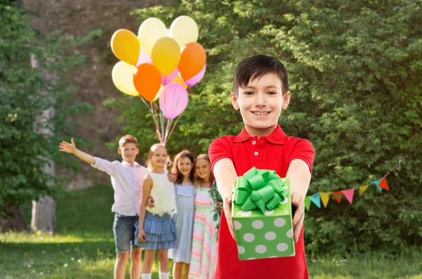 Niño con caja de regalo en la fiesta de cumpleaños en el parque de verano —  Fotos de Stock