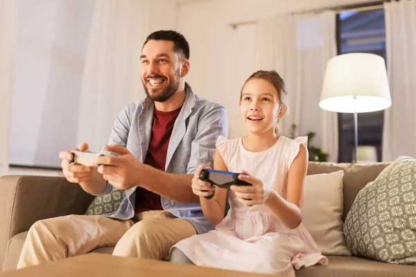 Père et fille jouer à un jeu vidéo à la maison — Photo