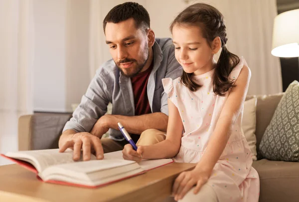 Baba ve kızı birlikte ev ödevi yapıyorlar. — Stok fotoğraf
