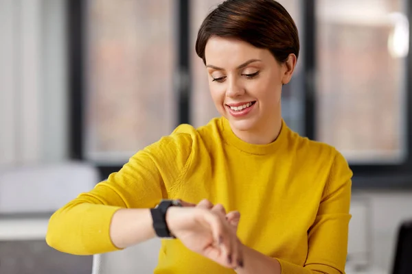 Zufriedene Geschäftsfrau mit Smart Watch im Büro — Stockfoto