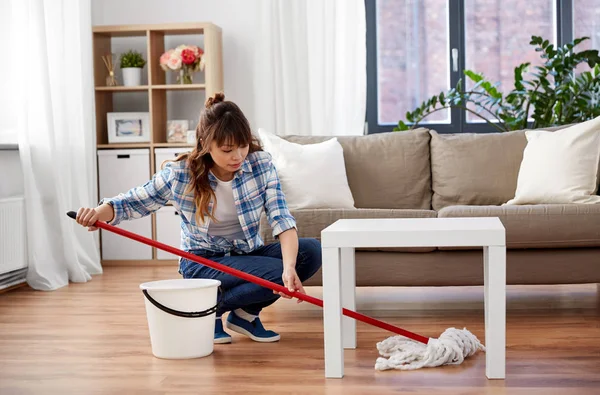 Evde paspas temizleme zemin ile mutlu asyalı kadın — Stok fotoğraf