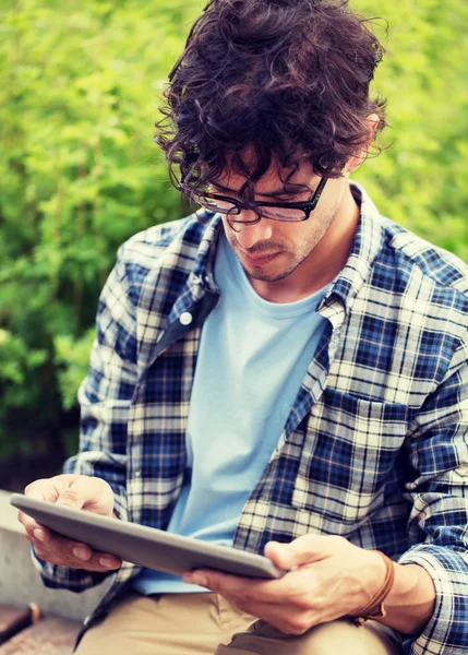 Man in glasses with tablet pc computer outdoors — Stock Photo, Image