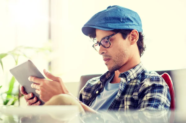 Hombre con la tableta PC sentado en la mesa de la cafetería — Foto de Stock