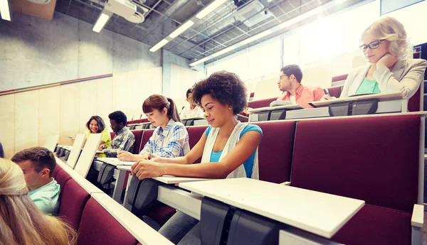 Grupo de estudiantes con cuadernos en la sala de conferencias —  Fotos de Stock