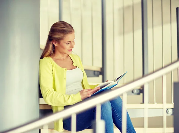 Uśmiechający się high school student dziewczyna czytanie książki — Zdjęcie stockowe