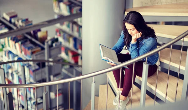 Estudante do ensino médio menina leitura livro na biblioteca — Fotografia de Stock