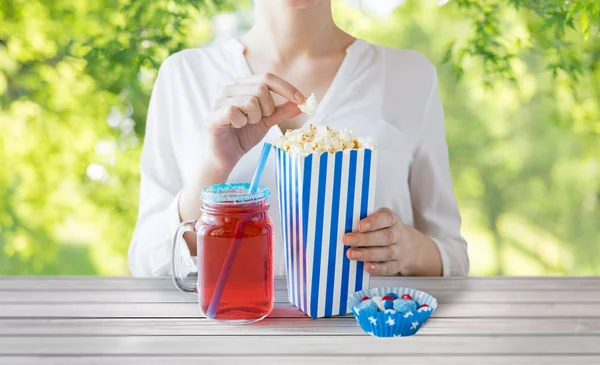 Mujer comiendo palomitas de maíz con bebida en tarro de cristal de albañil — Foto de Stock