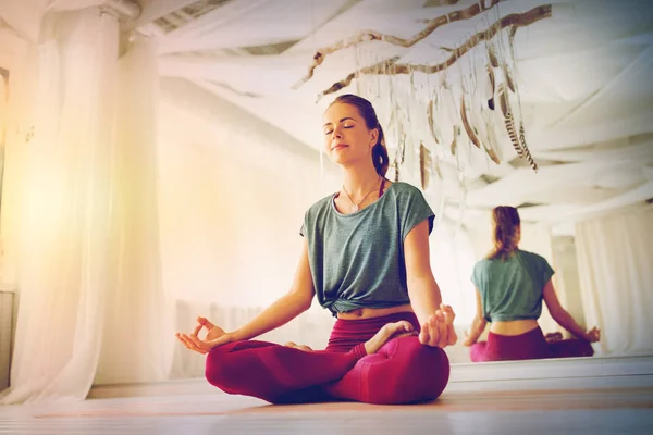 Vrouw mediteren in lotus poseren in yoga studio — Stockfoto