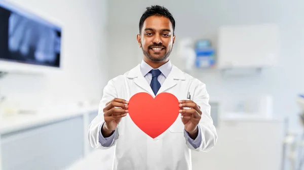 Dentista masculino con corazón rojo en clínica dental — Foto de Stock