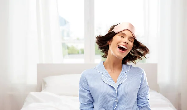 Mujer joven feliz en pijama y máscara para dormir — Foto de Stock