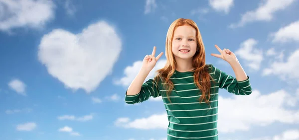 Усміхнена руда волохата дівчина показує мир над небом — стокове фото