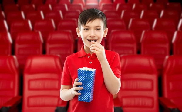 Усміхнений хлопчик їсть попкорн у кінотеатрі — стокове фото
