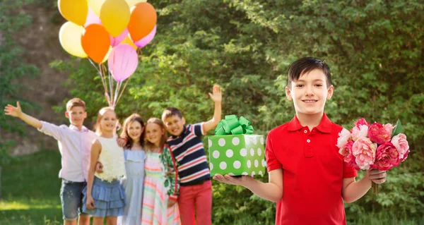 생일 파티에서 선물 상자와 꽃을 가진 소년 — 스톡 사진