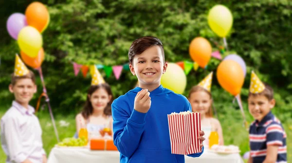 생일 파티에서 팝콘을 먹는 미소 짓는 소년 — 스톡 사진