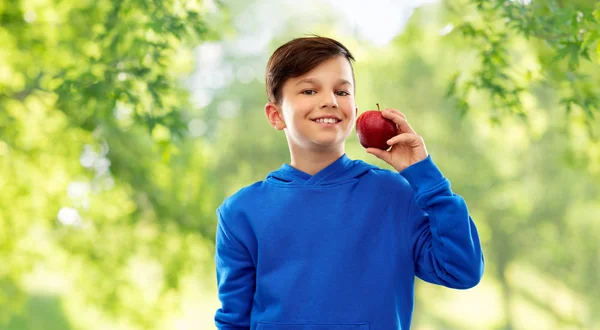 Garçon souriant avec pomme rouge en été — Photo