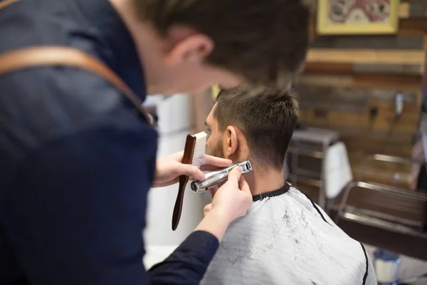 Cliente maschio e barbiere con trimmer taglio capelli — Foto Stock