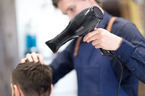 Cabeleireiro com secador de cabelo secagem cabeça masculina — Fotografia de Stock