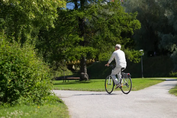 快乐的老人骑着自行车在夏天公园 — 图库照片