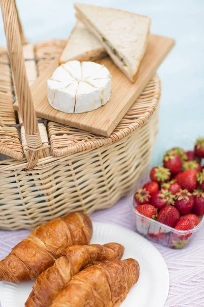Picnic basket, food and wine glasses on blanket — Stock Photo, Image