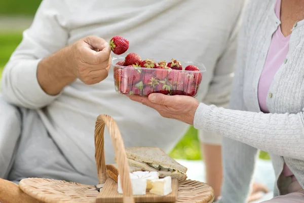 Senior couple eating strawberries at picnic — Stock Photo, Image