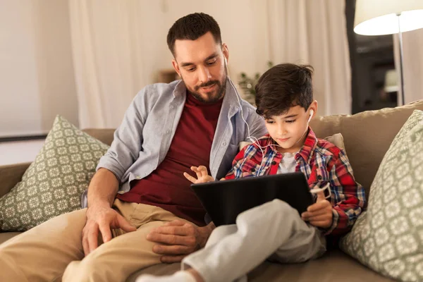 Батько і син слухають музику на планшетному ПК — стокове фото