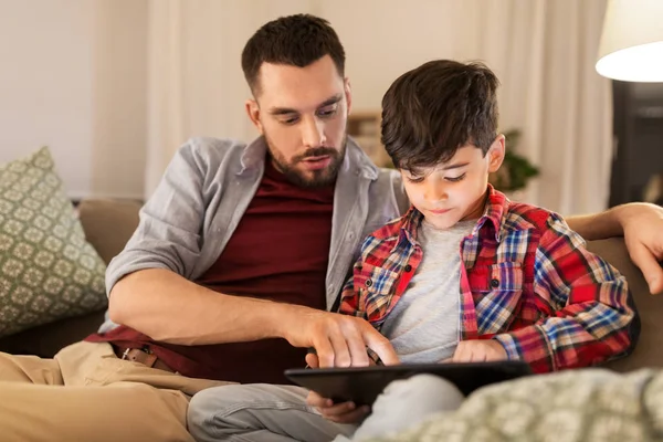 Far och son med tablet pc spelar hemma — Stockfoto