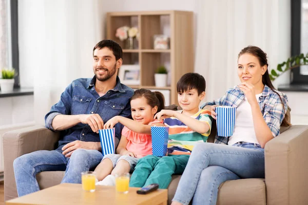 Famiglia felice con popcorn guardando la tv a casa — Foto Stock