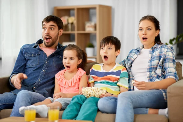 Patlamış mısırlı korkmuş bir aile televizyonda korku seyrediyor. — Stok fotoğraf