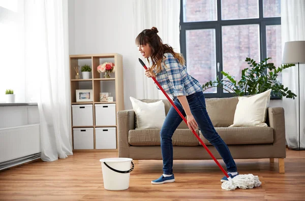 Feliz asiático mujer con fregona limpieza piso en casa — Foto de Stock