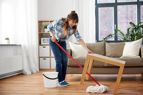 Heureux asiatique femme avec balai nettoyage plancher à la maison — Photo