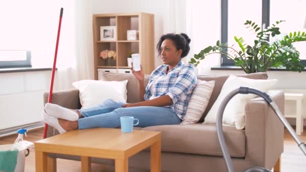 Woman calling on smartphone after home cleaning — Stock Video