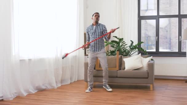 Uomo con scopa pulizia e divertirsi a casa — Video Stock