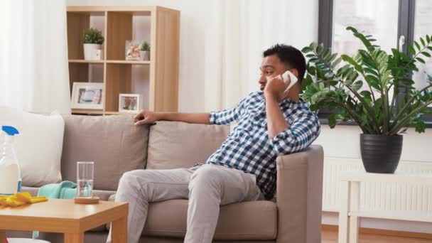 Hombre que llama en el teléfono inteligente después de limpiar casa — Vídeo de stock