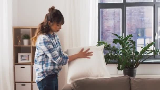 Азиатка раскладывает диванные подушки дома — стоковое видео
