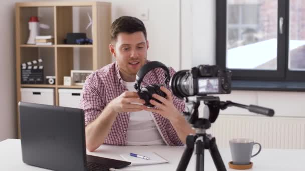 Męski blogger ze słuchawkami videoblogging w domu — Wideo stockowe