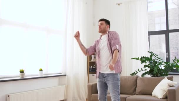 Fröhlicher junger Mann tanzt zu Hause — Stockvideo