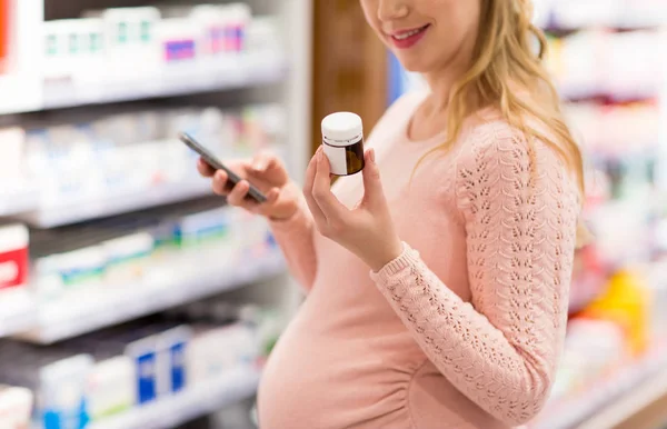 Mulher grávida escolhendo remédio na farmácia — Fotografia de Stock